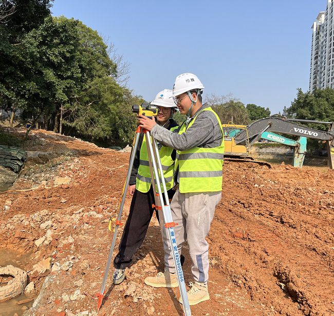 （修图）闫益海在施工现场测量标高.jpg